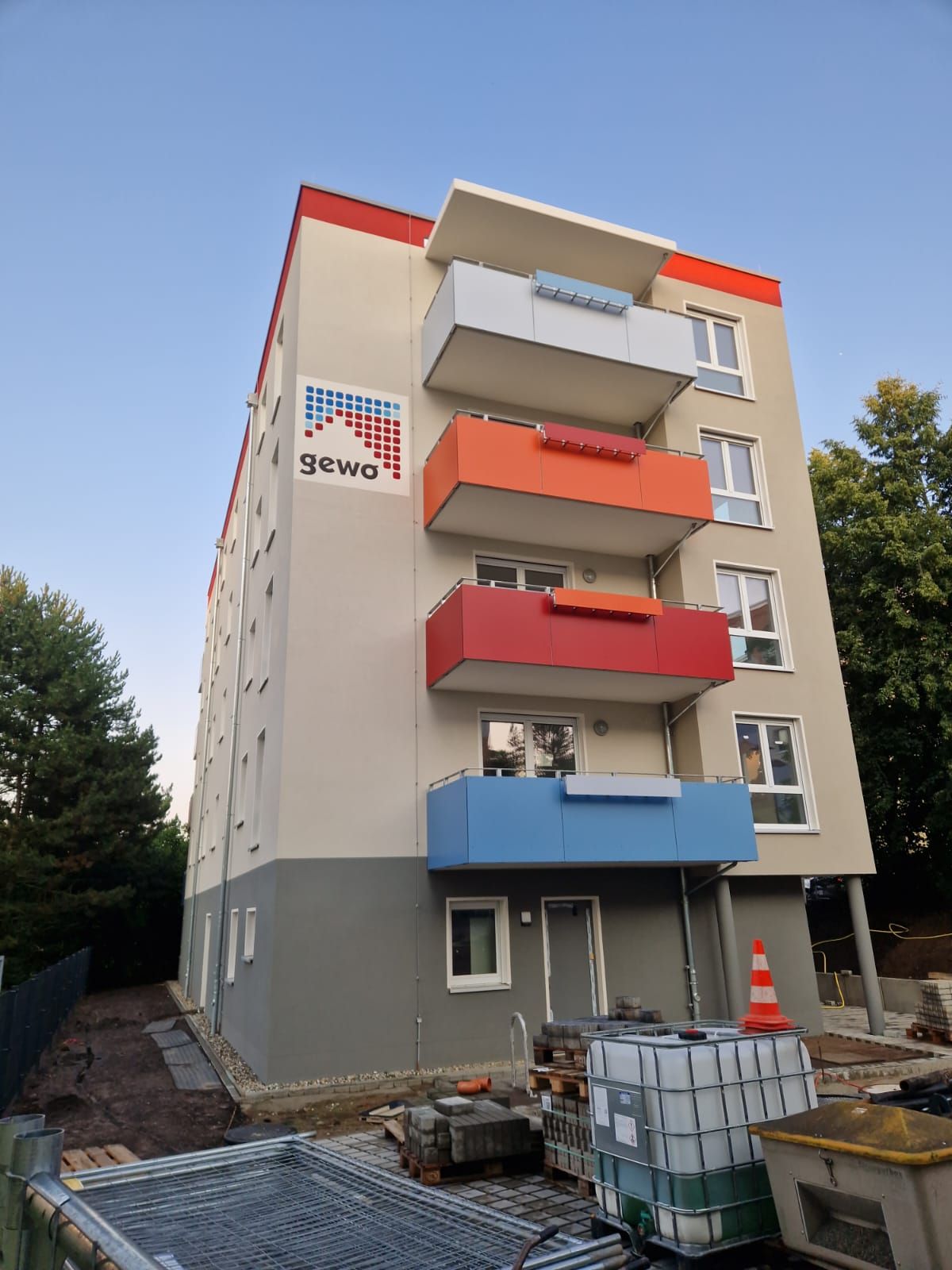 Modernisiertes Wohngebäude in Freital mit roten Balkonen und heller Fassade