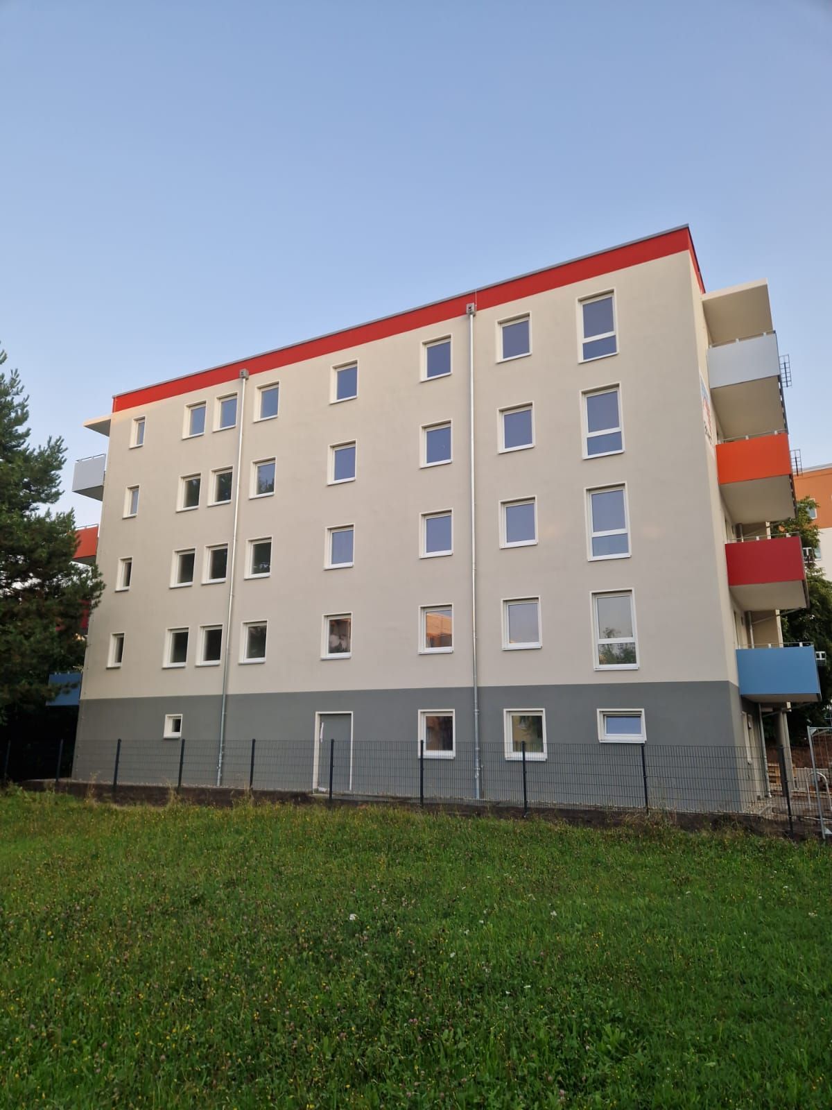 Wohnanlage in Freital mit renovierter Fassade und roten Farbakzenten