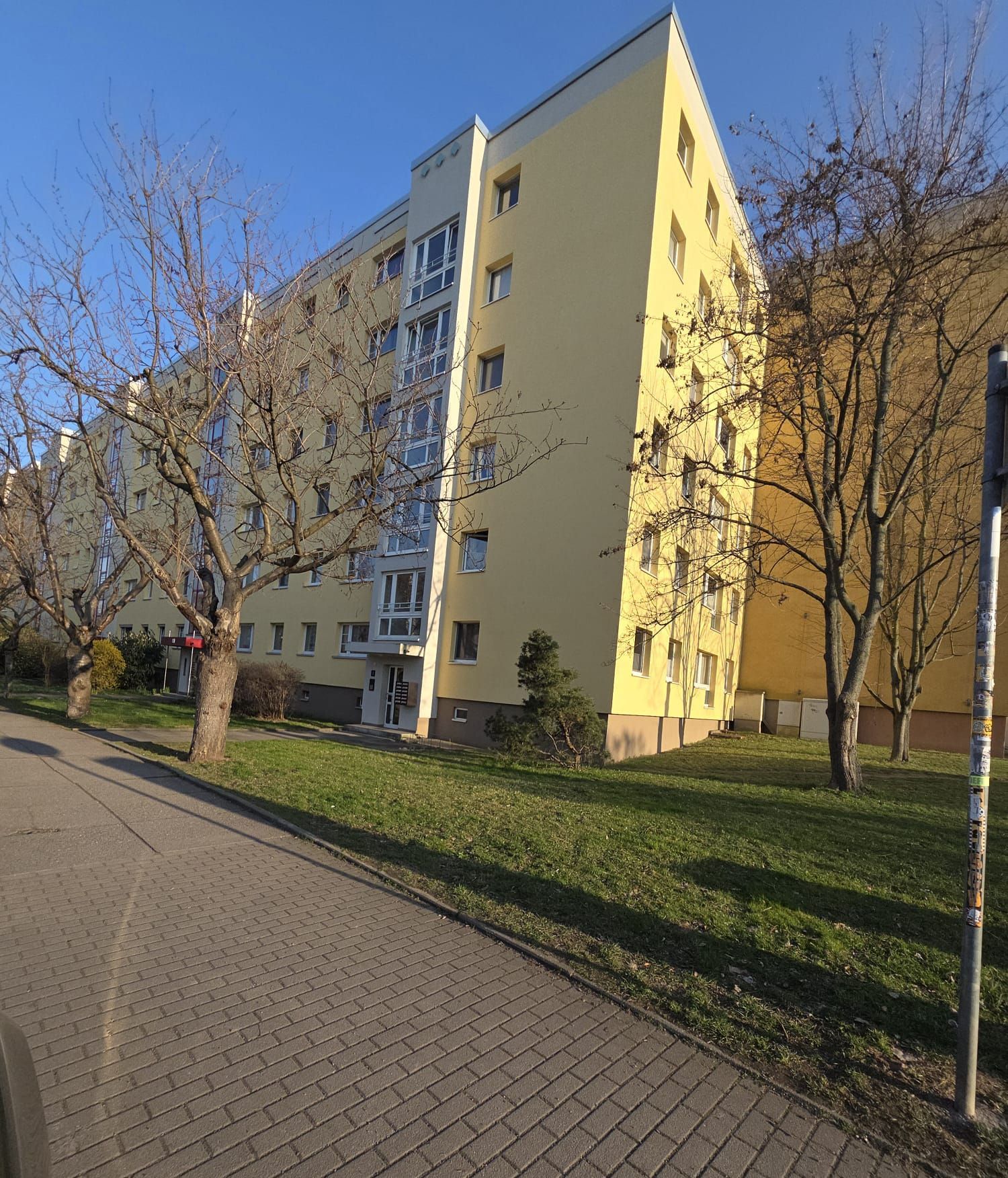 Mehrstöckiges Wohnhaus mit renovierter Fassade und klarer Architektur