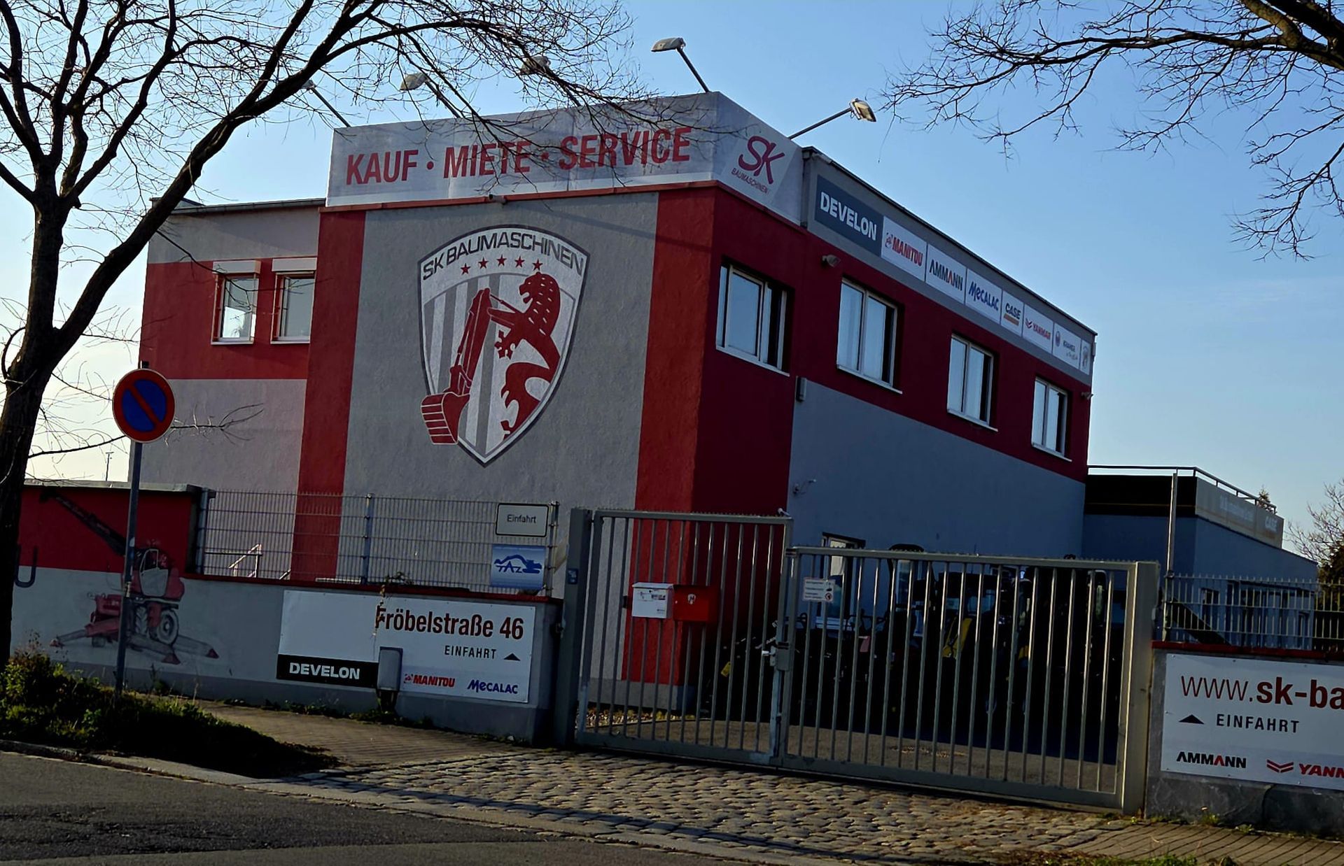 Gewerbegebäude mit roter Fassade und Firmenschild in urbaner Umgebung