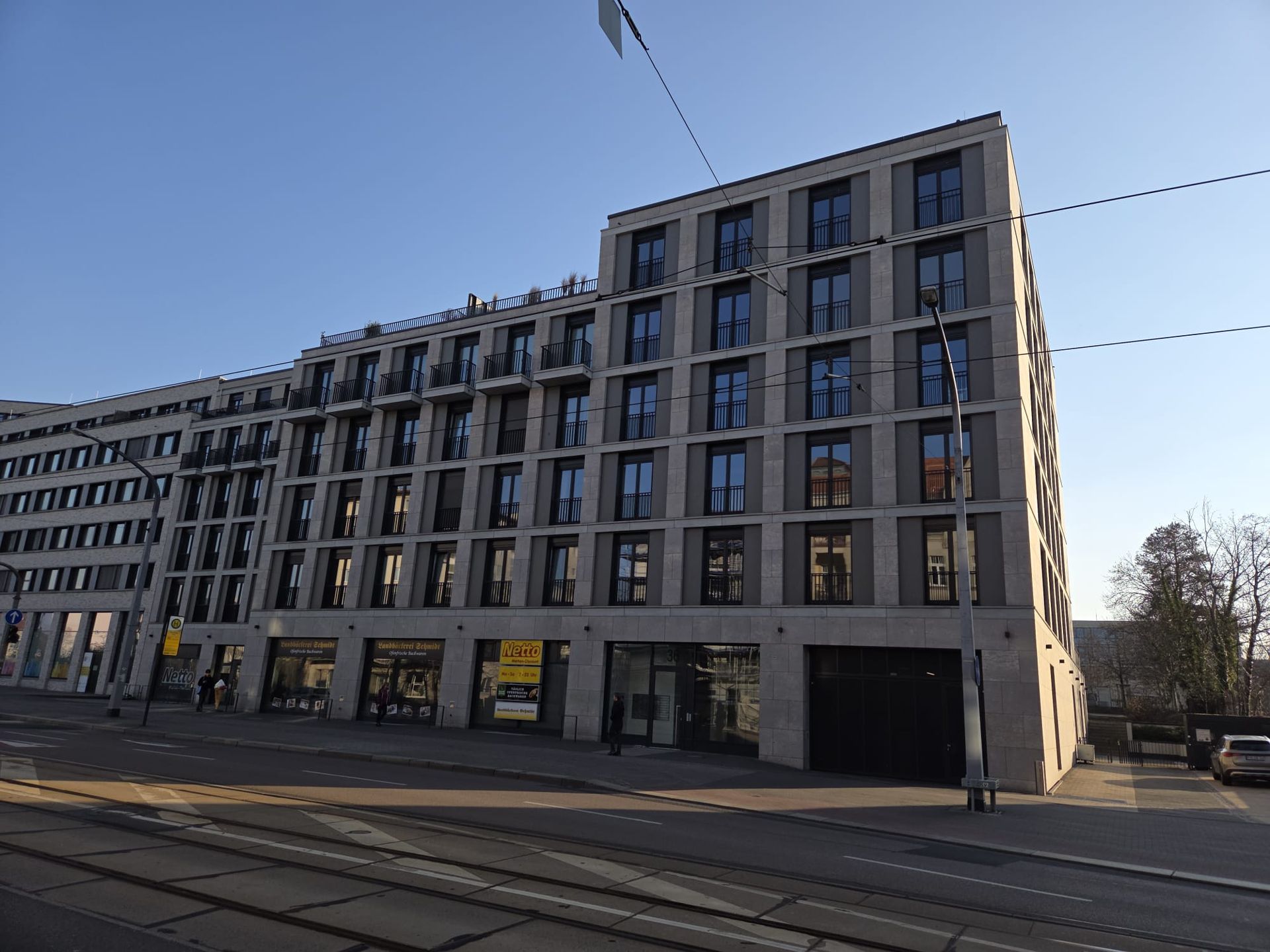 Urbanes Wohn- und Geschäftshaus mit moderner Fassade und großen Fenstern