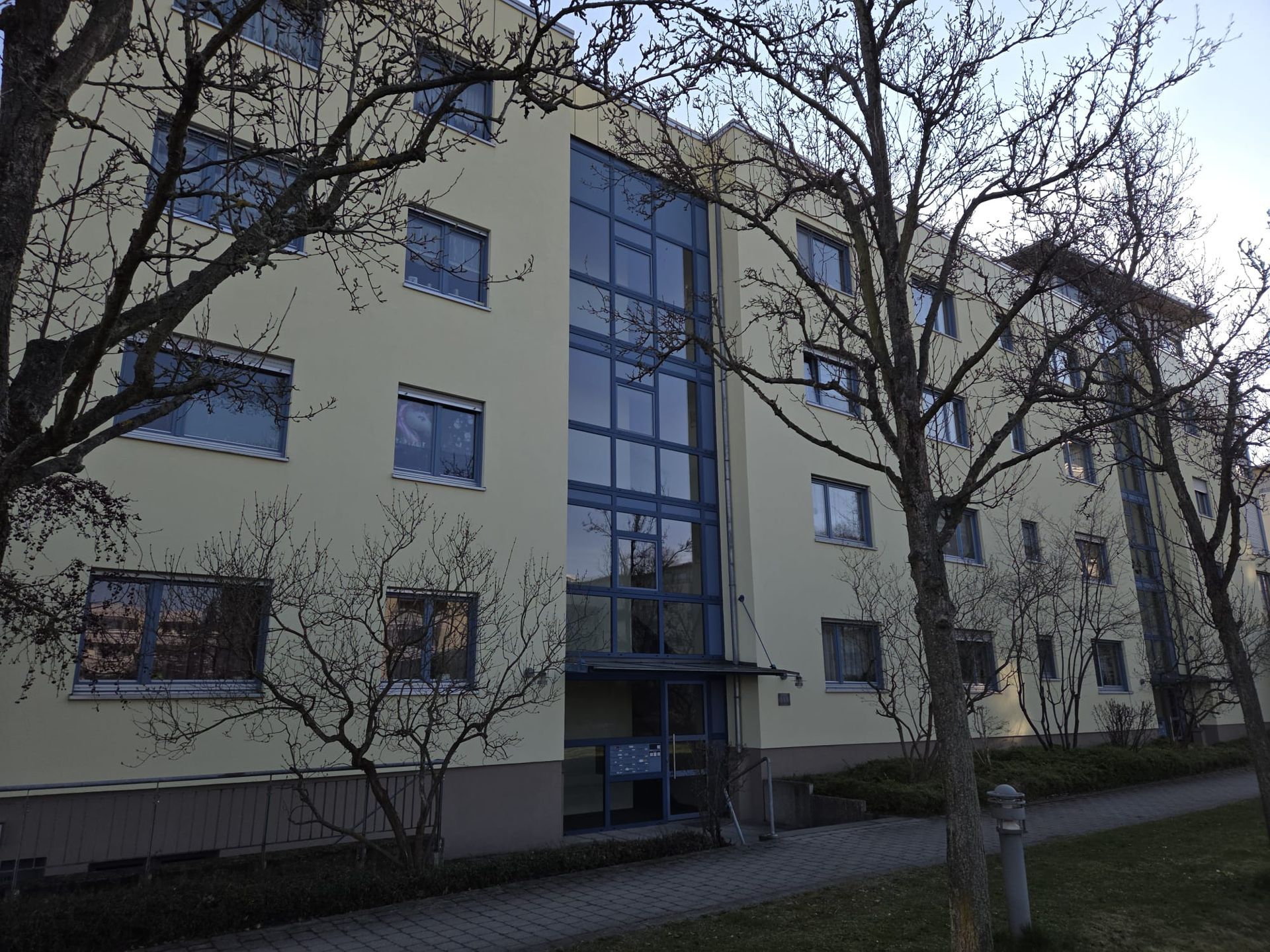 Wohnhaus mit moderner Architektur und Glasfassade, umgeben von Bäumen