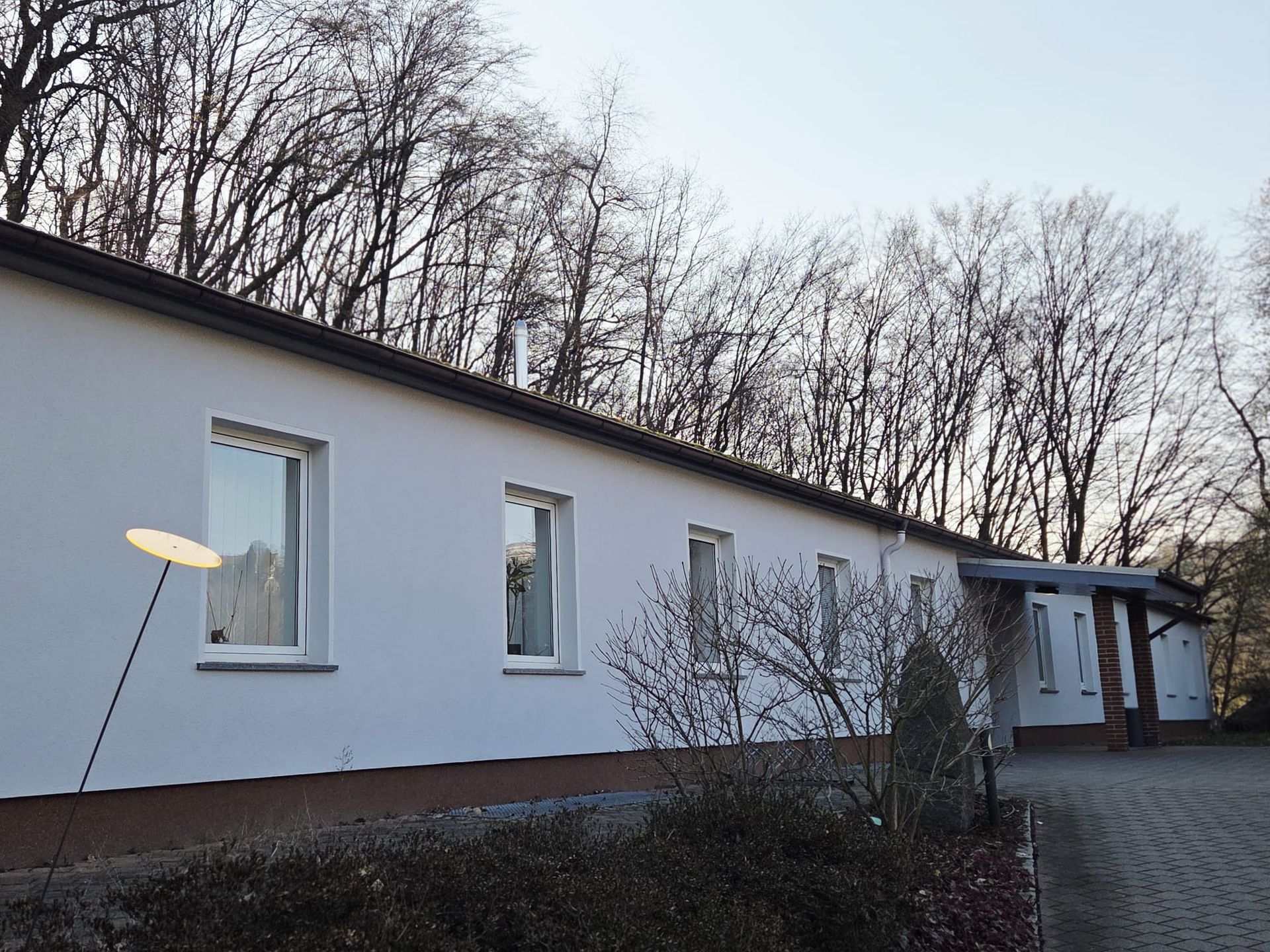 Langes eingeschossiges Gebäude mit mehreren Fenstern und ruhiger Umgebung