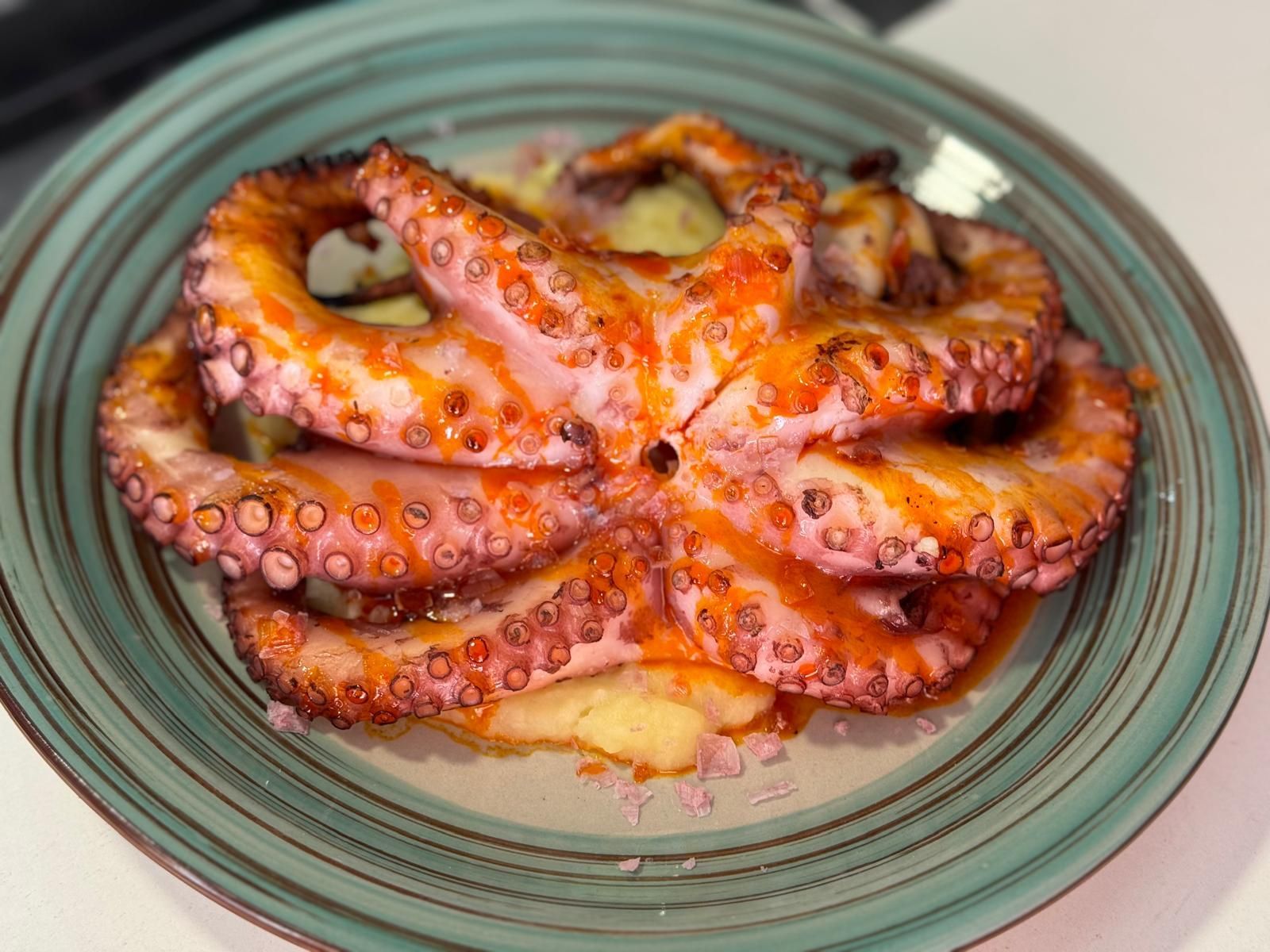 Un primer plano de un plato de pulpo sobre una mesa.