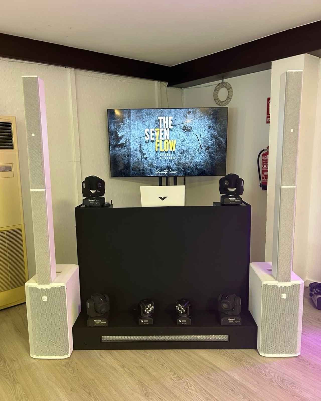 Configuración de DJ con altavoces, luces, pantalla que muestra 