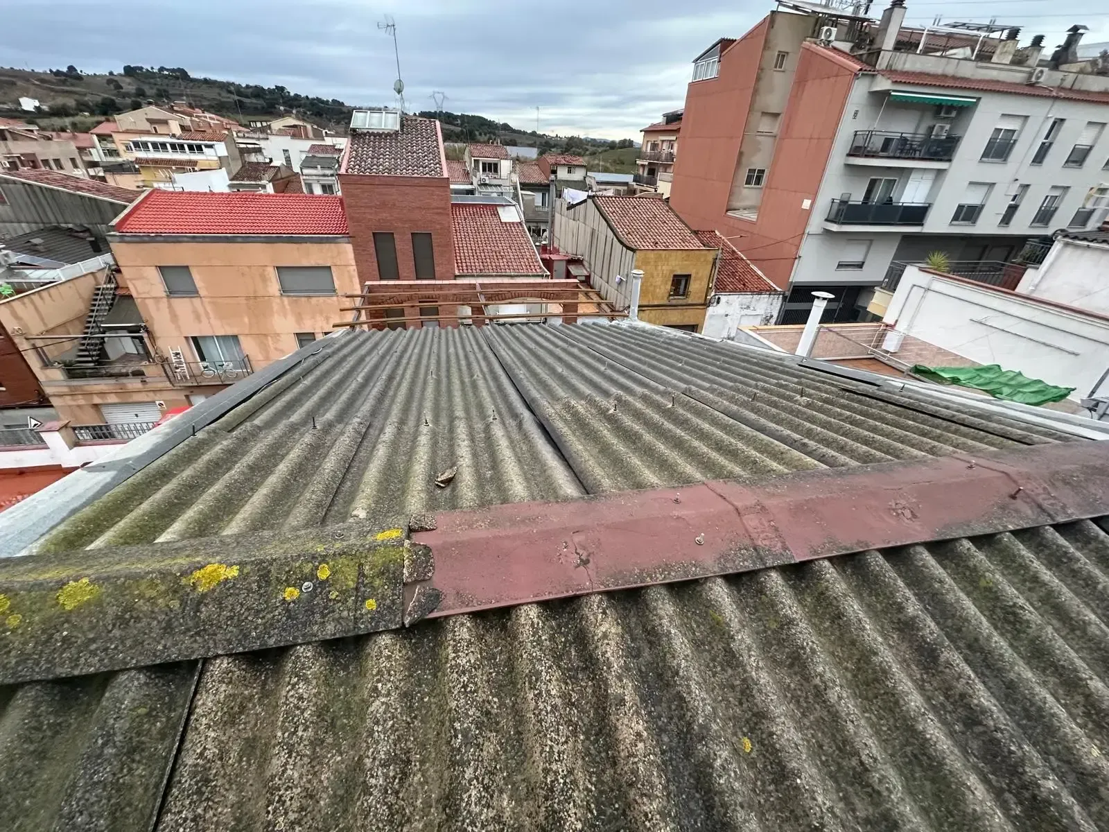 Vista desde una azotea de casas antiguas y edificios de apartamentos bajo un cielo nublado
