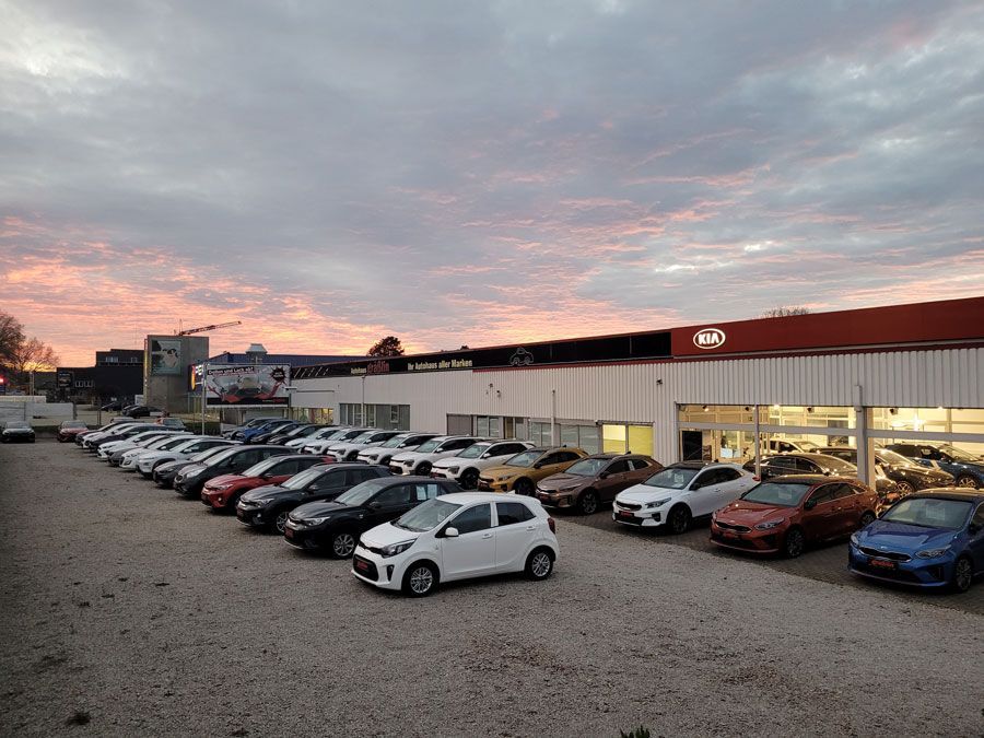 Vor einem Autohaus parken viele Autos.