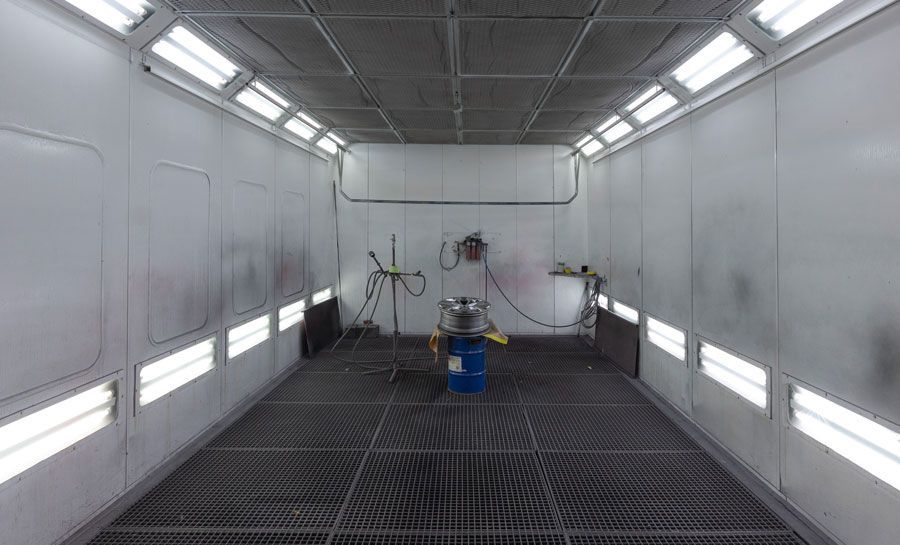 Eine große leere Lackierkabine mit Metallboden.