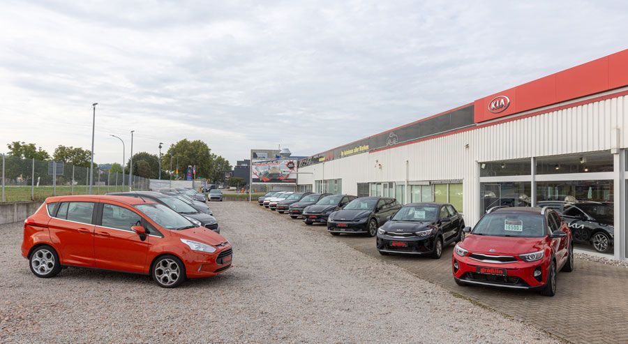 Vor einem Autohaus parkt eine Reihe Autos.