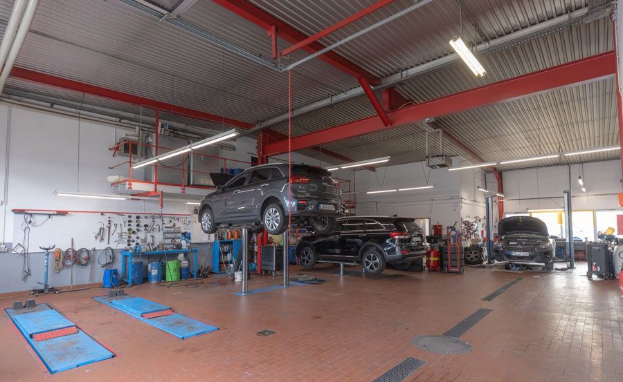 Ein Auto steht auf einer Hebebühne in einer Garage.