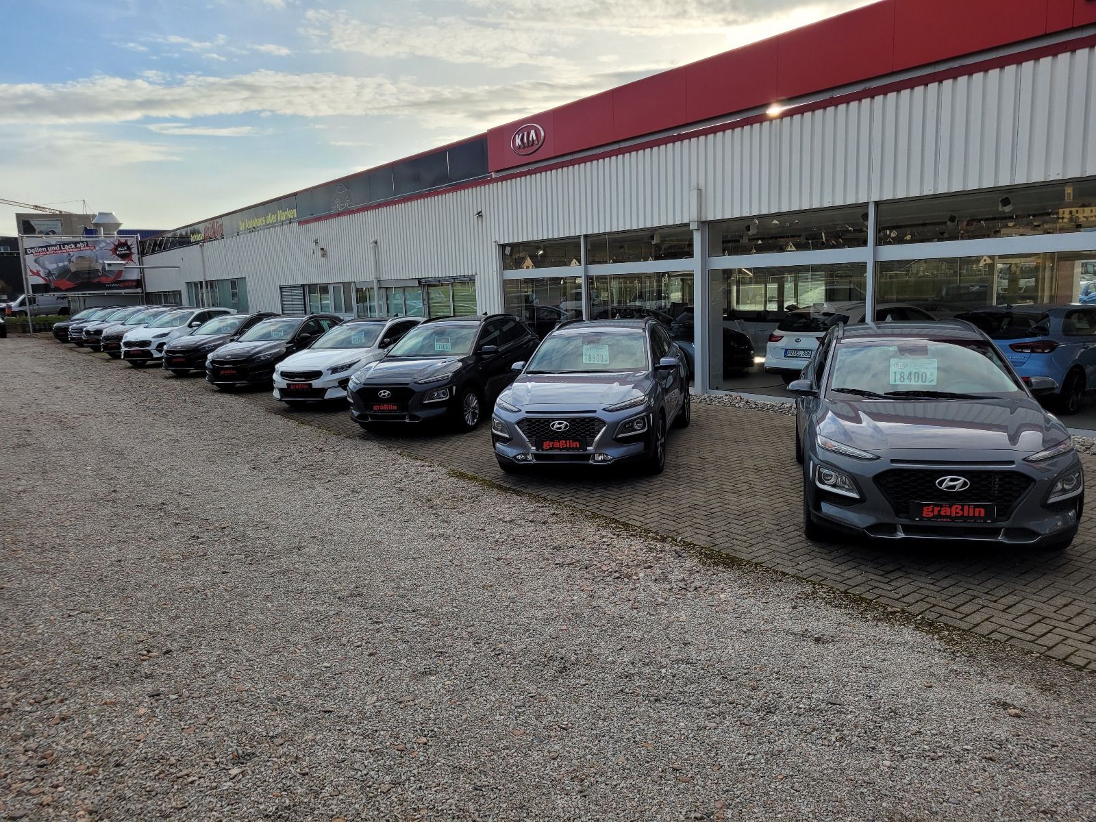 Vor einem Autohaus parkt eine Reihe Autos.