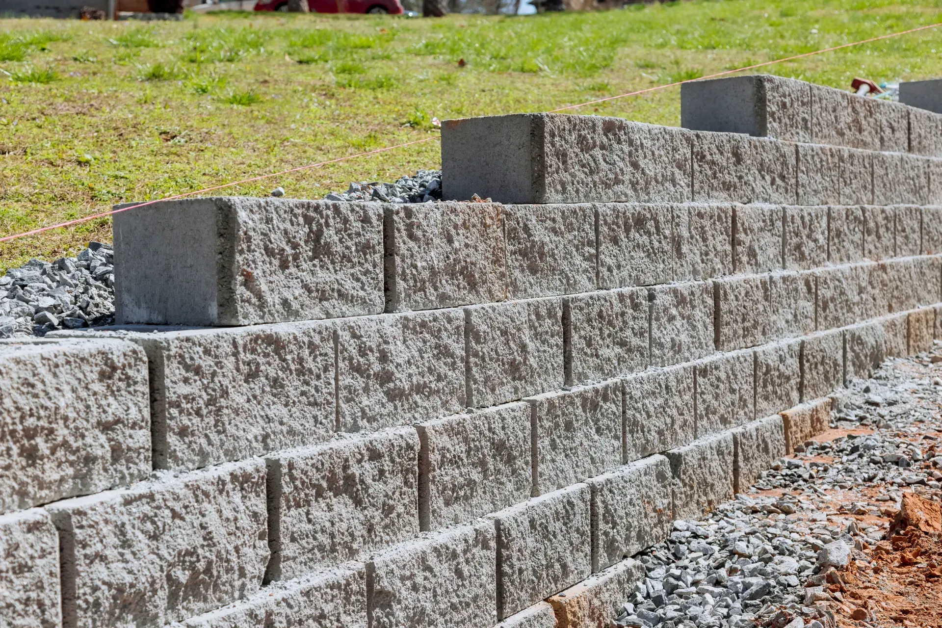 Se está construyendo un muro de ladrillos en la cima de una colina cubierta de hierba.