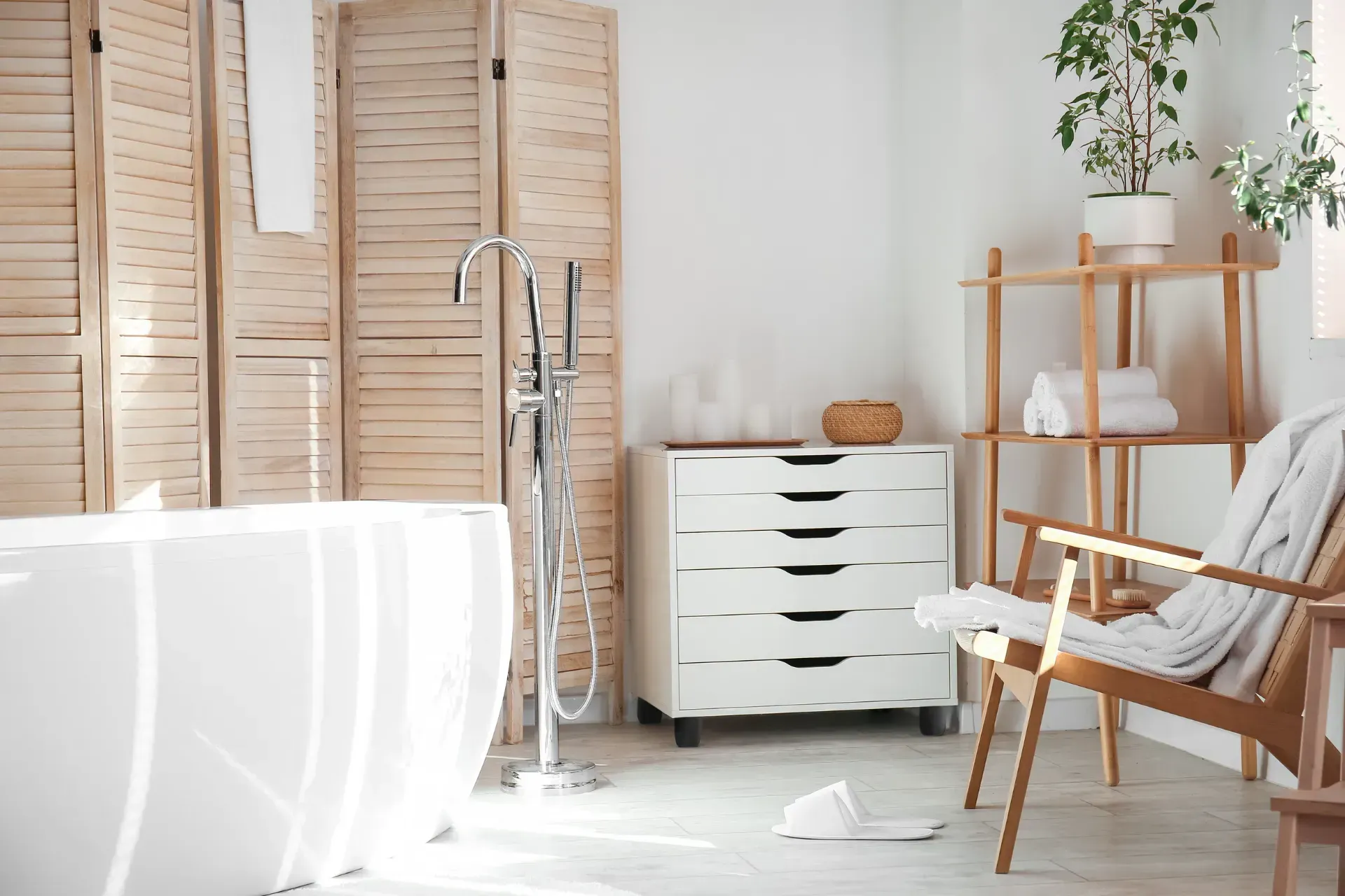 Un baño con bañera, tocador, silla y planta.