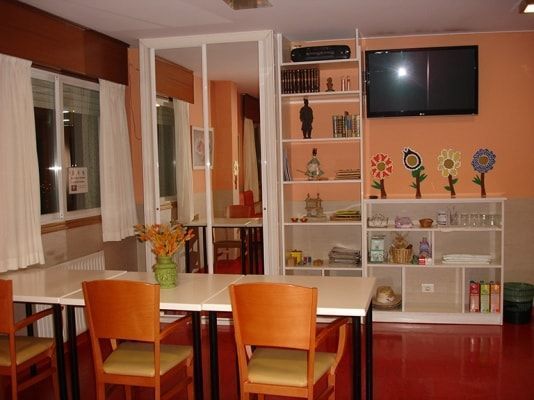 Una sala de estar con mesas y sillas y un televisor de pantalla plana.