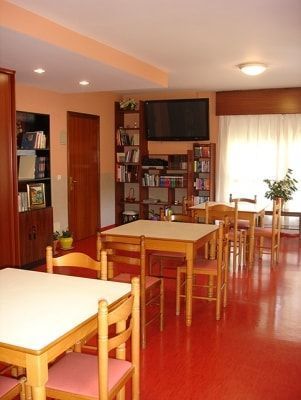 Una sala de estar con mesas y sillas y un televisor de pantalla plana.