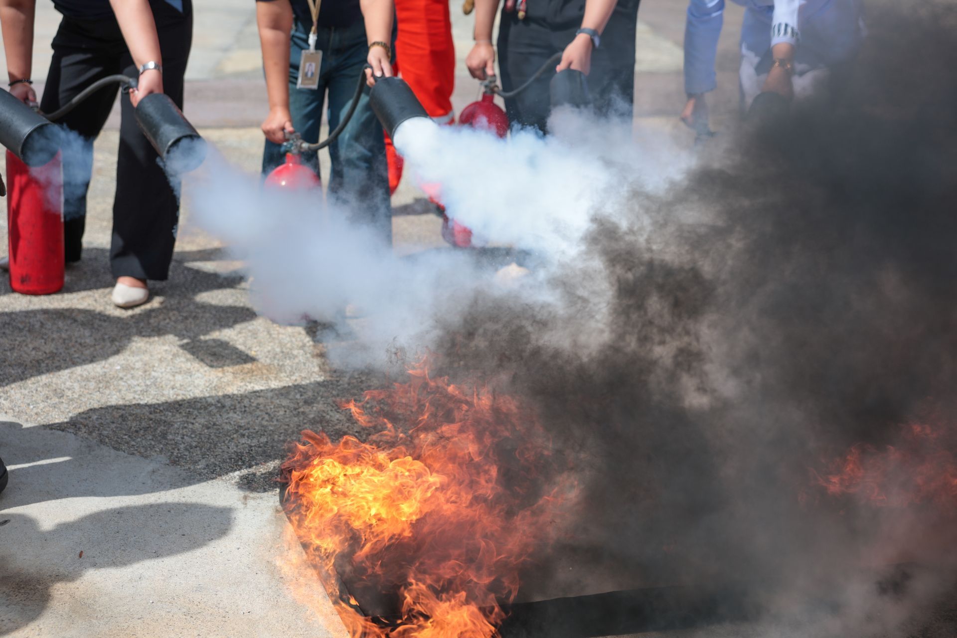 Des personnes utilisent des extincteurs sur un objet en feu.
