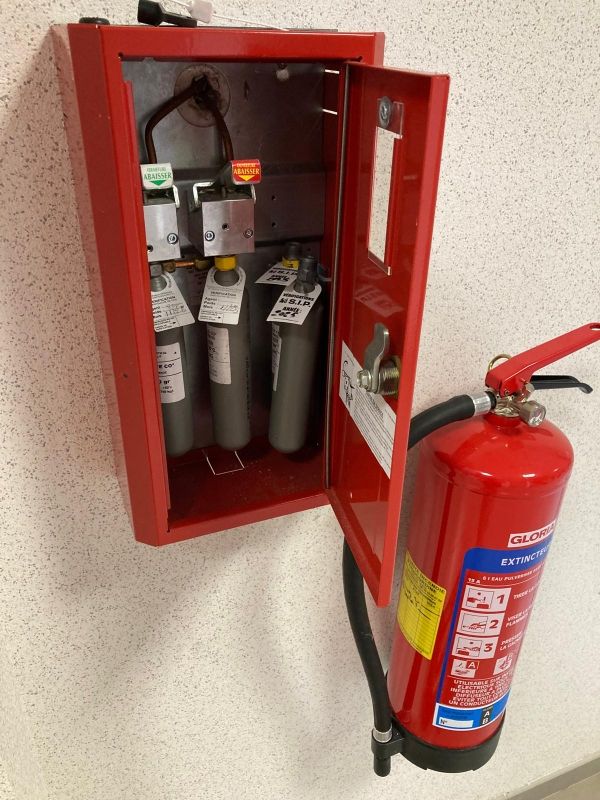 Un homme qui contrôle un extincteur