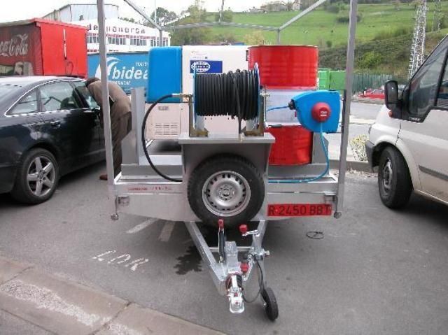 Un remolque con una manguera conectada está estacionado en un estacionamiento.