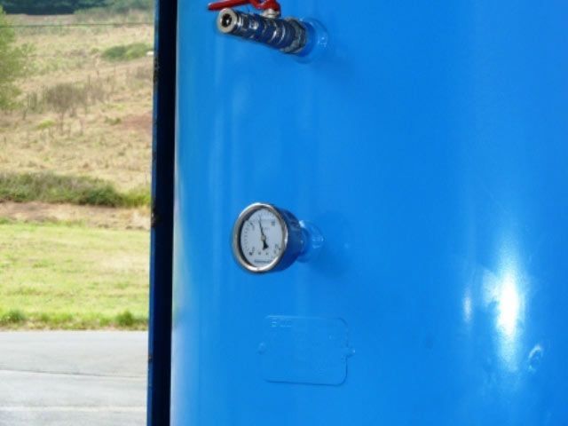 Un primer plano de un tanque azul con un indicador en él.