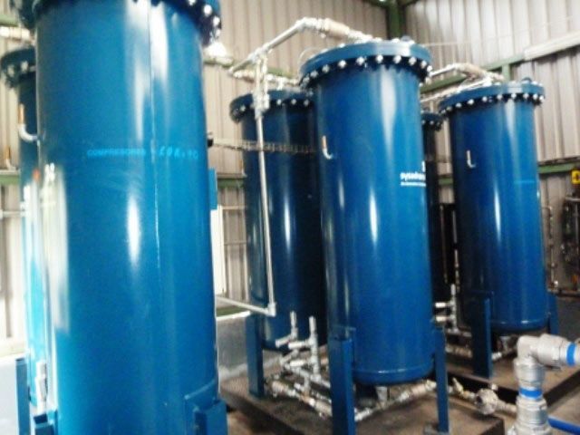 Tres tanques azules están sentados uno al lado del otro en una habitación.