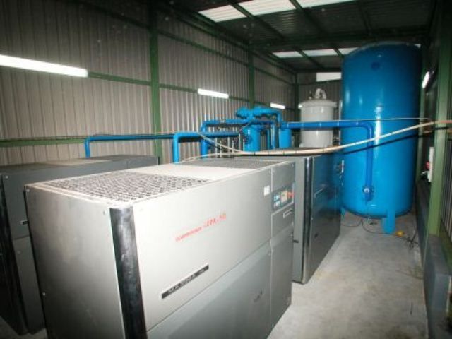 Un gran tanque azul está en el medio de un almacén.