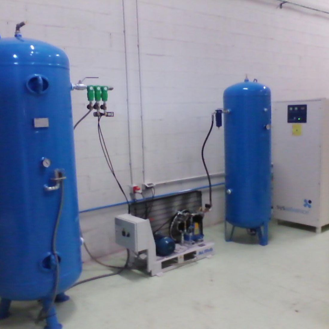 Dos tanques azules están en una habitación con una pared blanca.