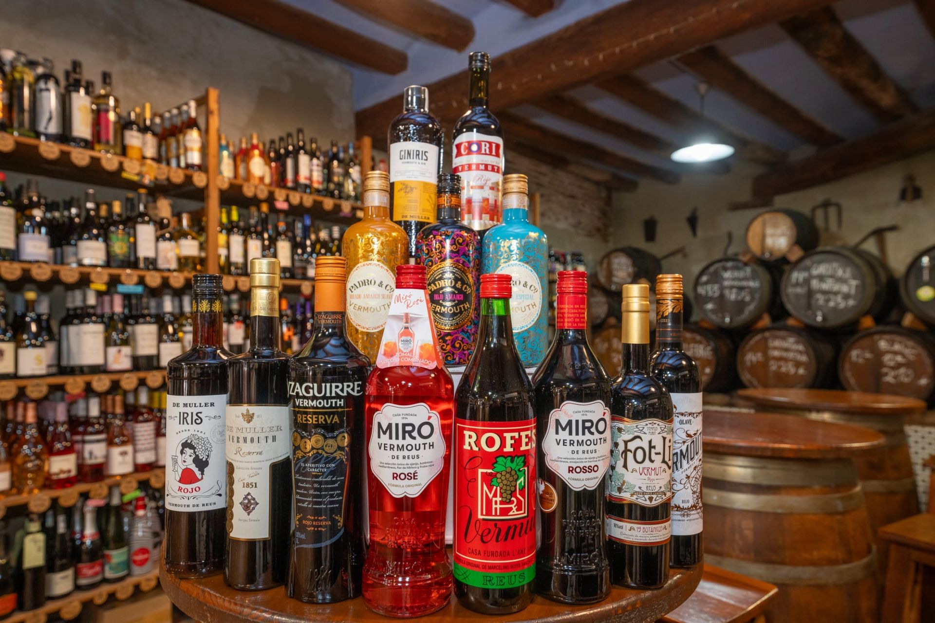 Una colección de botellas de diversas bebidas alcohólicas dispuestas sobre una mesa en una bodega