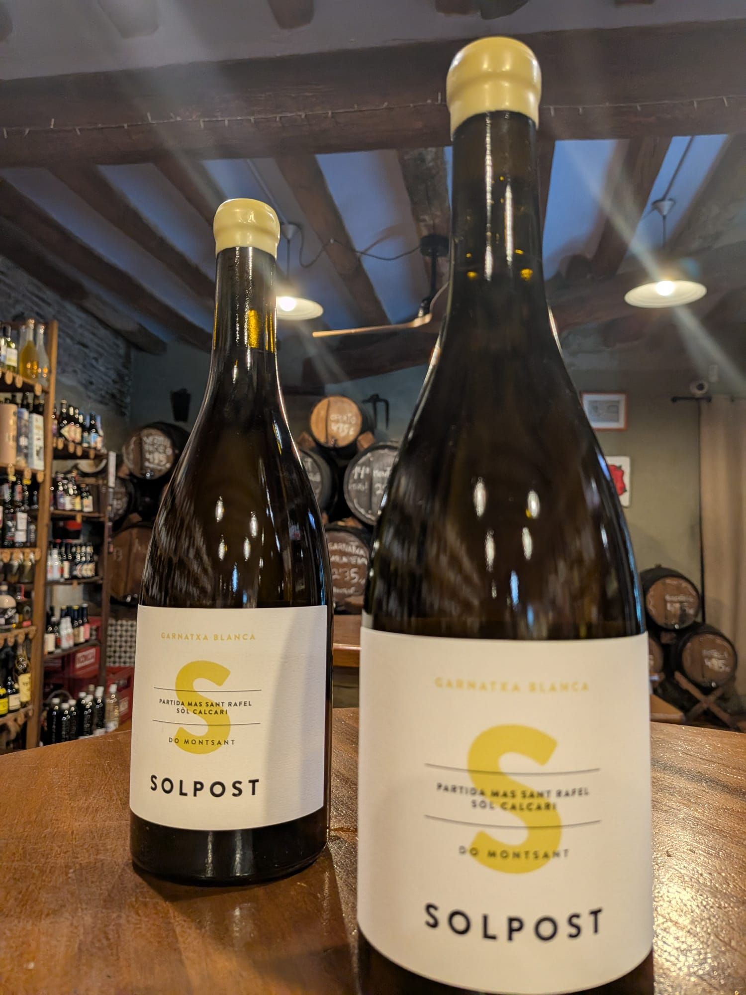 Dos botellas de vino Solpost con etiquetas blancas y una gran 