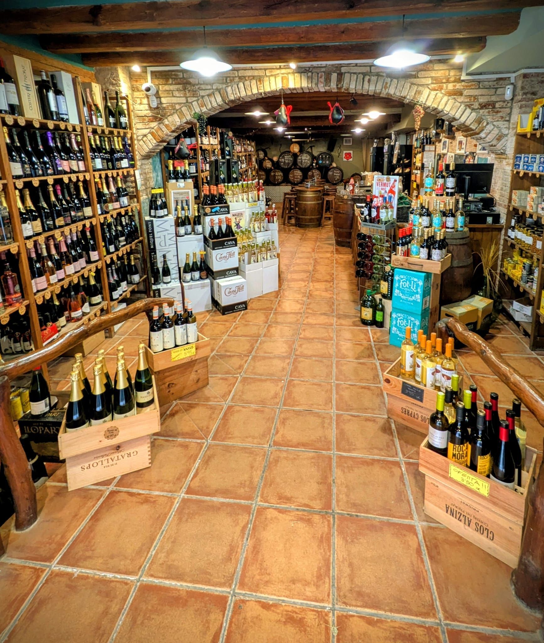 El interior de una vinoteca bien surtida, con estanterías y cajas de madera repletas de botellas