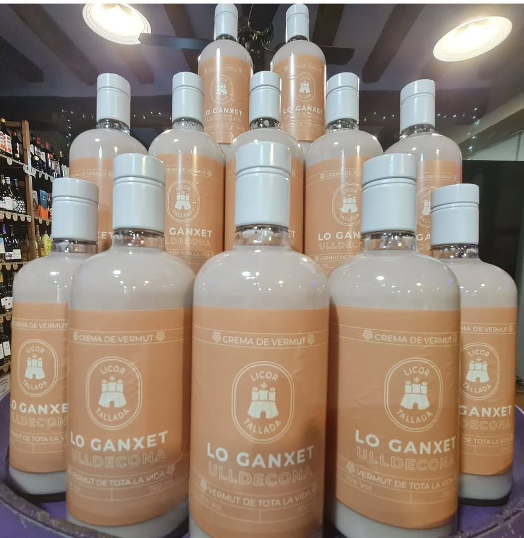 Varias botellas de licor de crema Lo Ganxet con etiquetas de color marrón claro dispuestas 