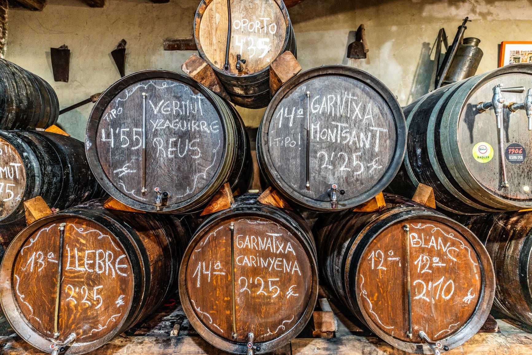 Una pared de barricas de madera para vino apiladas en una bodega