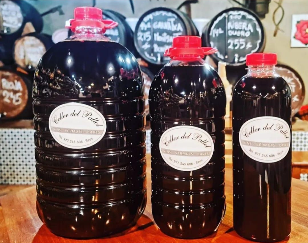 Tres botellas de plástico oscuro con etiquetas blancas, que representan el vino tinto