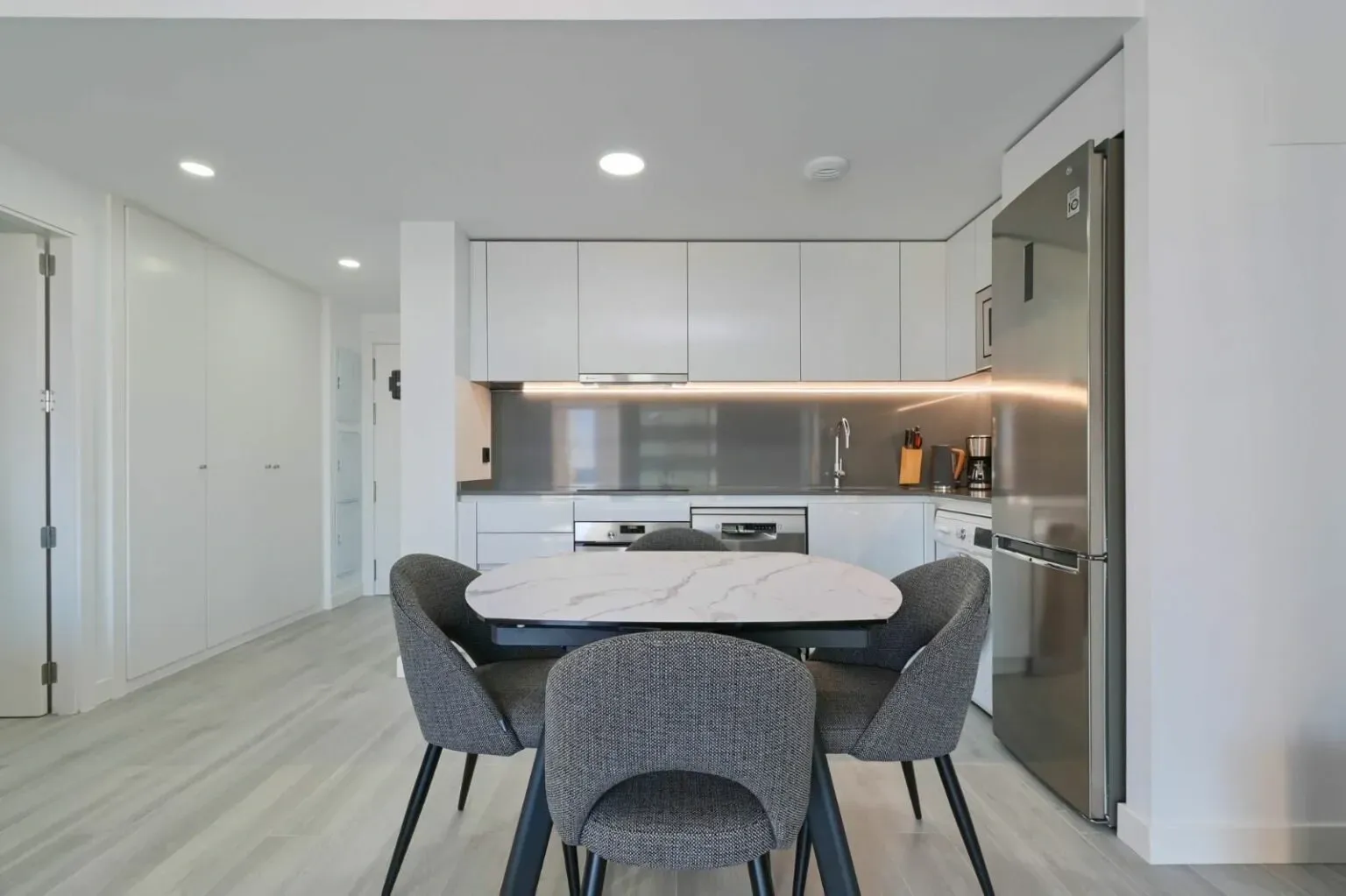 Cocina con comedor, paredes en todos blancos.