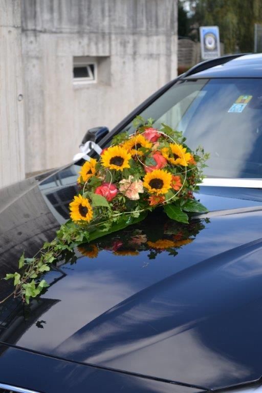 Ein schwarzes Auto mit Sonnenblumen auf der Motorhaube