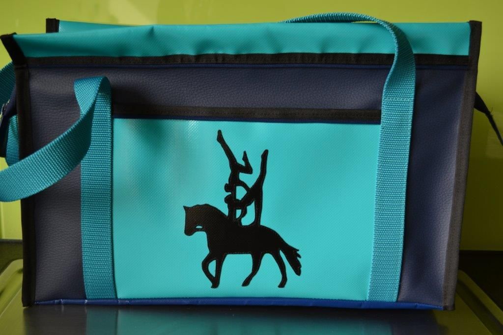 Eine blau-schwarze Tasche mit der Silhouette einer Person auf einem Pferd