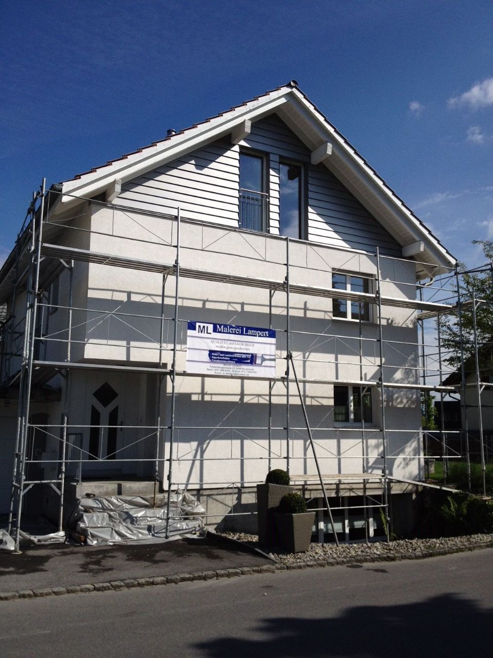 Gerüst an einer Hausfassade, Arbeit der Malerei Lampert