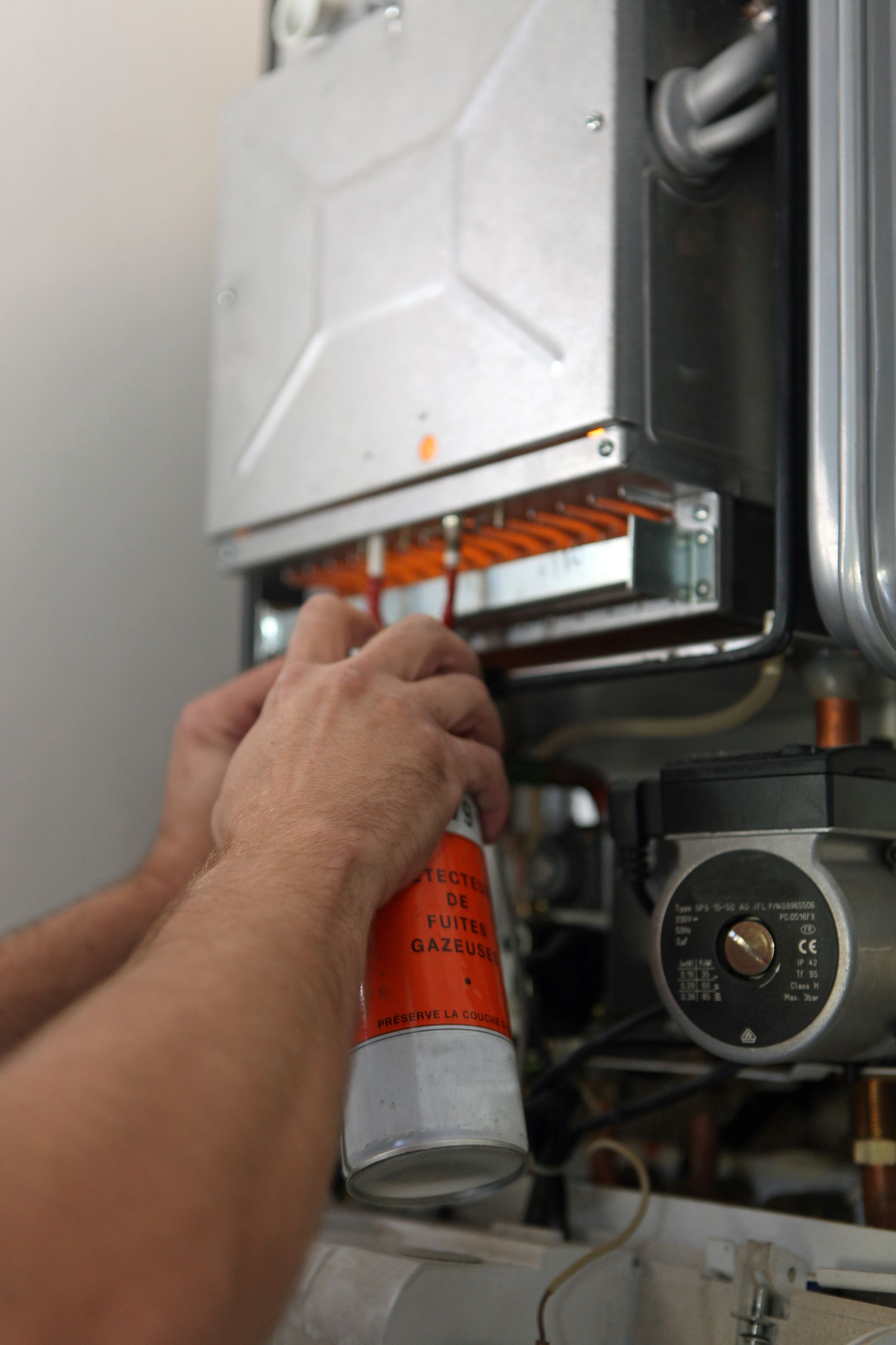 Personne effectuant l'entretien d'une chaudière à fioul.