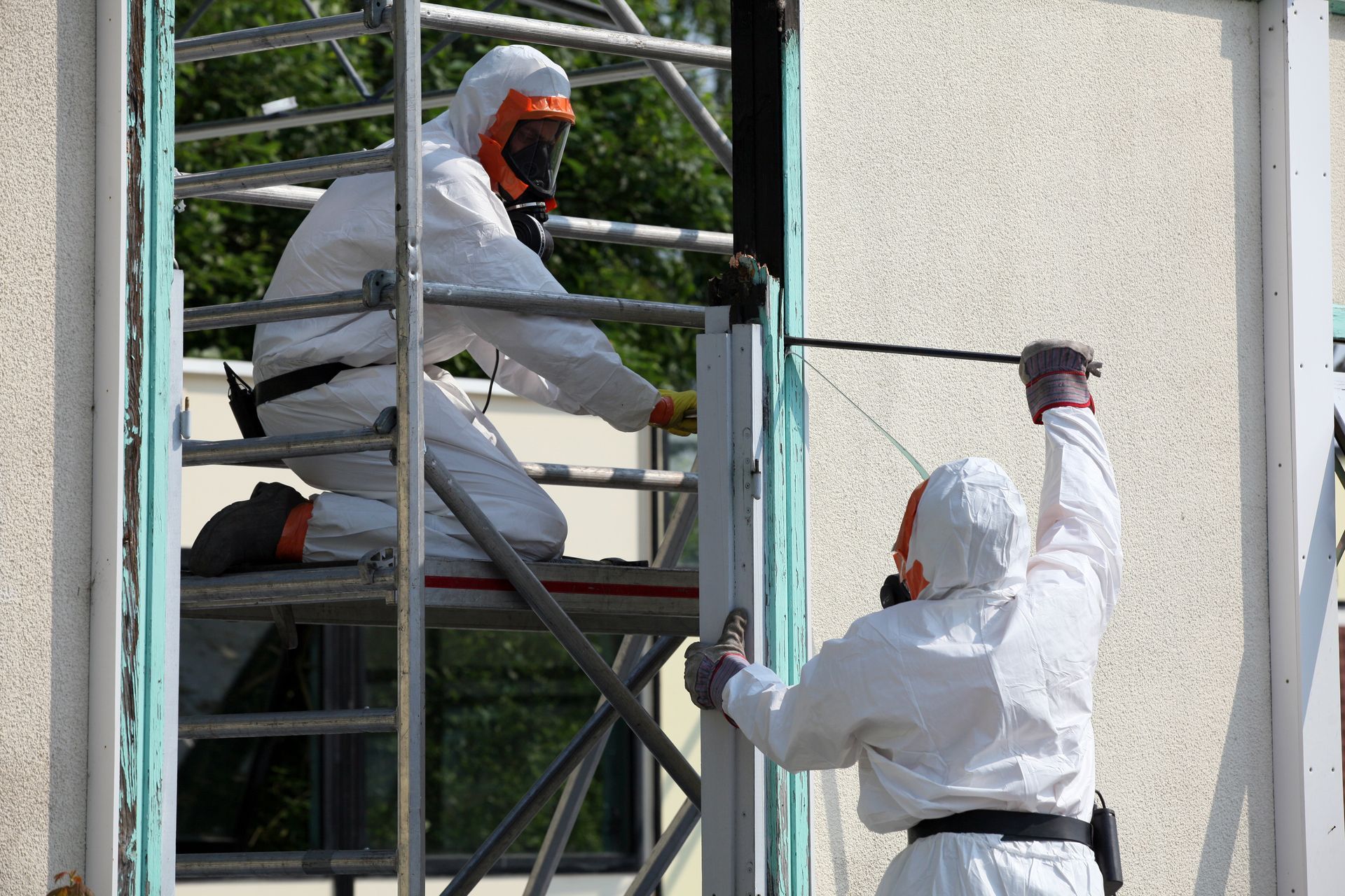 Équipe de désamianteurs travaillant sur un mur