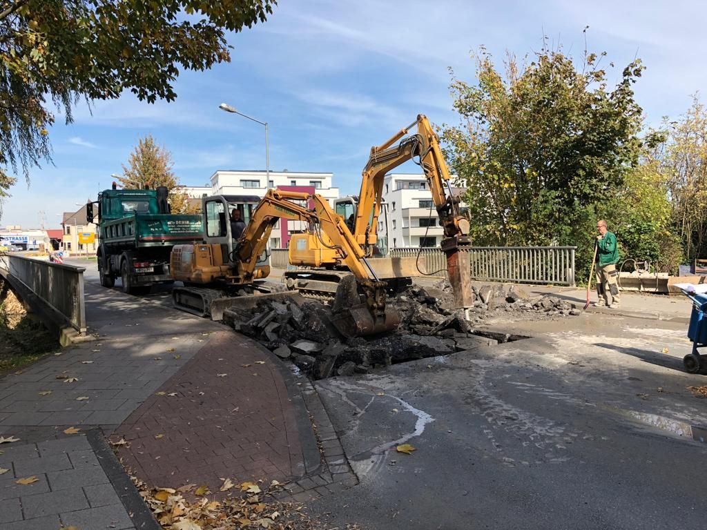 Eine Gruppe von Baufahrzeugen arbeitet an einer Straße.