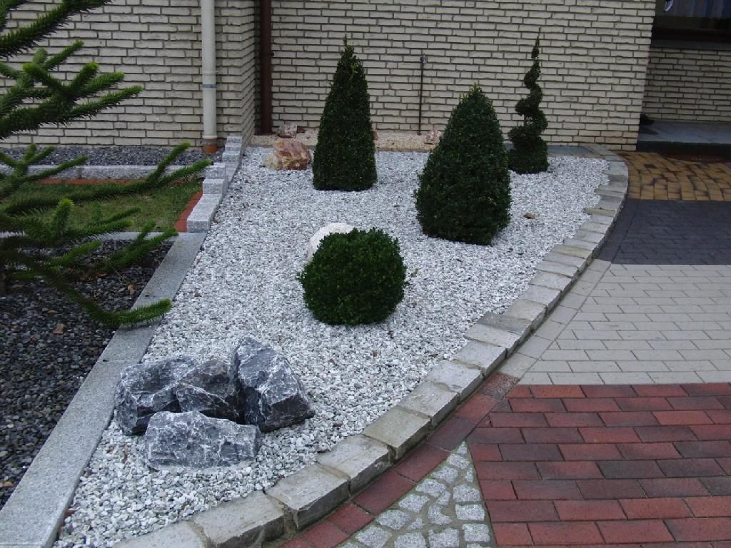 Ein Garten mit Felsen und Büschen vor einem Backsteingebäude