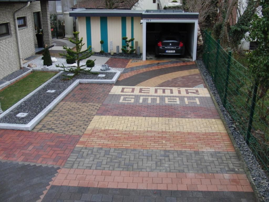 Ein Auto steht in einer Garage neben einer Einfahrt mit der Aufschrift Demir GmbH