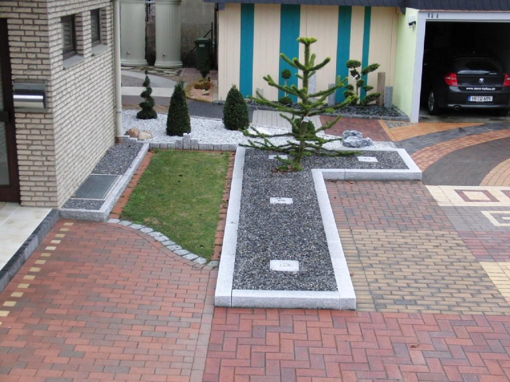 Ein Auto steht in einer Garage neben einer gepflasterten Auffahrt