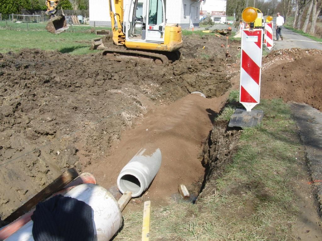 Ein gelber Bagger gräbt ein Loch in den Boden