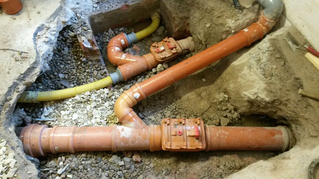 In einem Loch im Boden liegen mehrere Rohre.