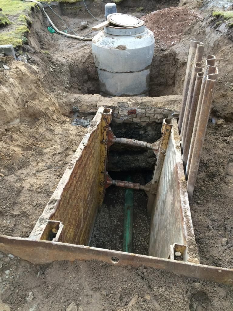 In einem Loch im Boden wird eine Klärgrube installiert.