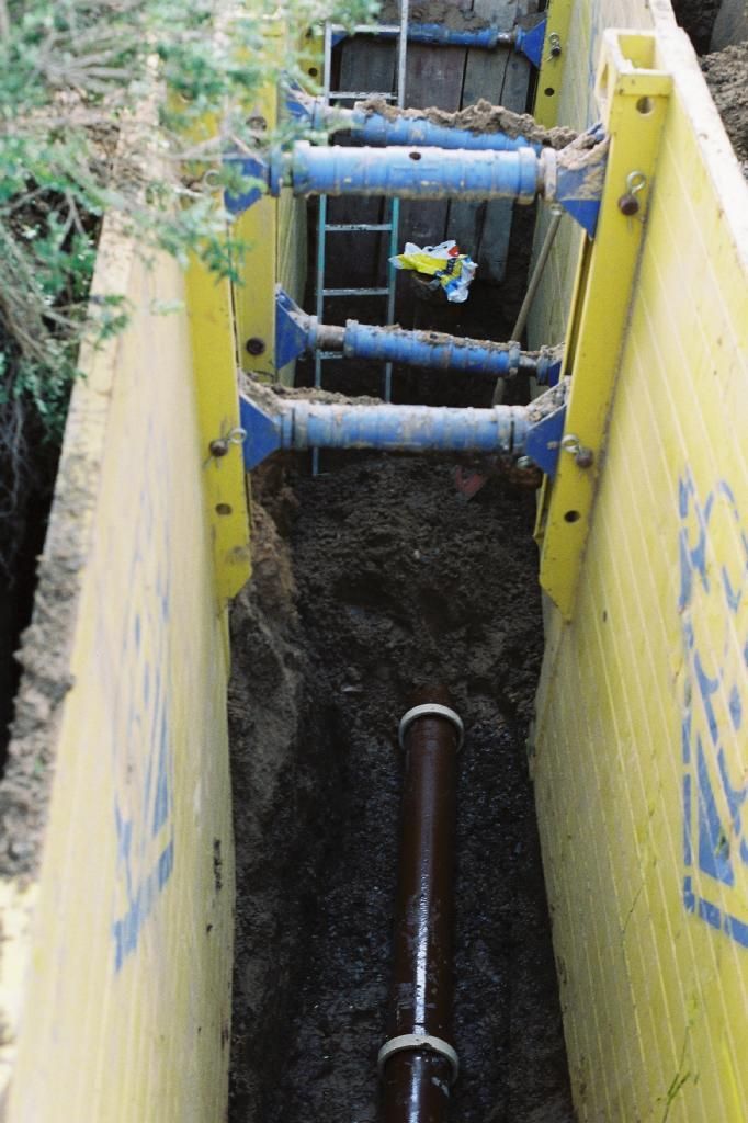 Ein gelb-blauer Graben mit einem Rohr darin