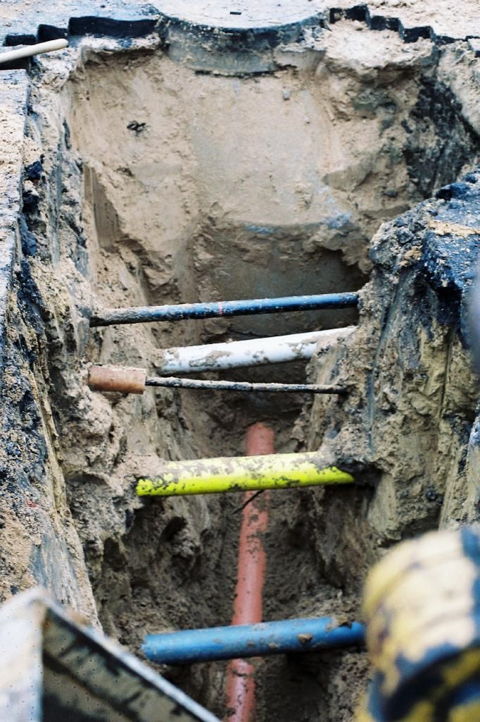 Ein Mann gräbt ein Loch in den Boden und steckt ein Rohr darin.