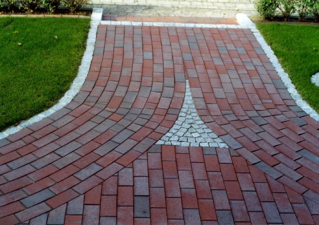 Ein rot-schwarzer Ziegelweg mit weißem Rand