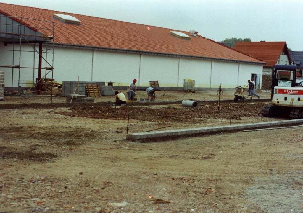 Ein Bobcat steht vor einem im Bau befindlichen Gebäude