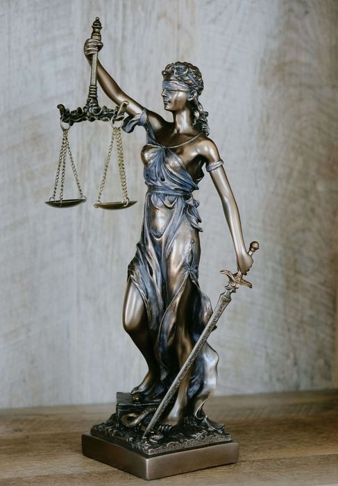 Pronssinen Lady Justice -patsas, jossa on vaa'at ja miekka jalustalla